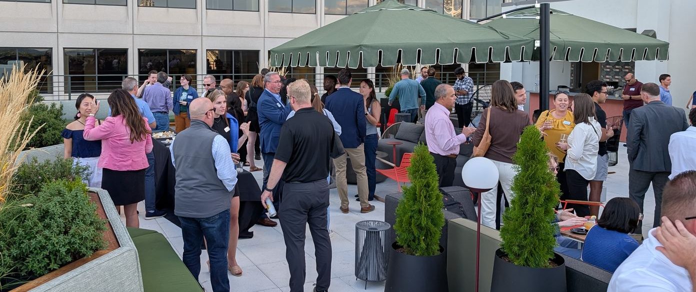 Professionals networking on the Moxy Hotel rooftop overlooking downtown Cincinnati at a Connect Cincy mixer